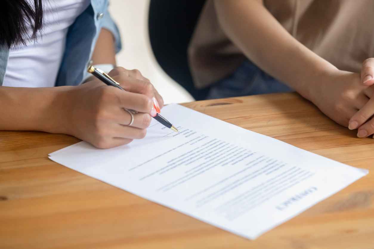 Close up female client signing business contract, Protecting Your Business in Divorce