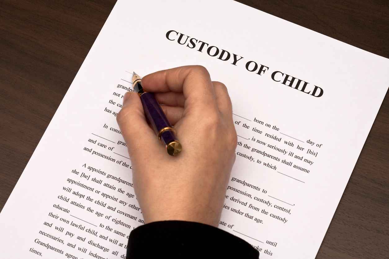 Female hand filling custody of child form